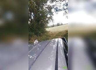 Prise en levrette  dans la voiture sur une route de campagne